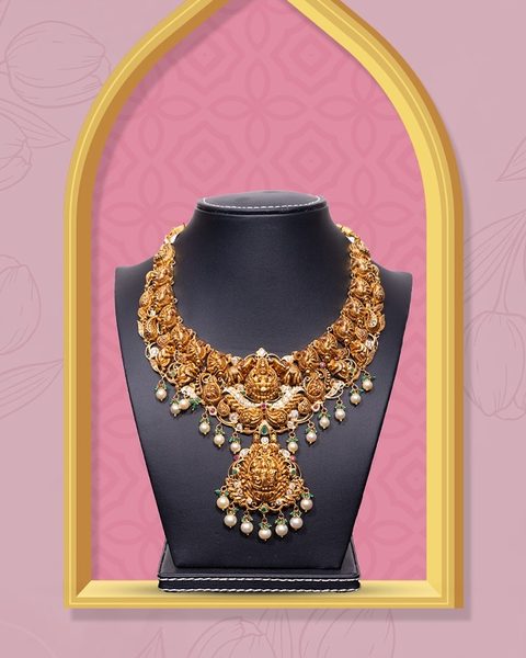 Nakshi choker with lakshmi pendant, peacock panels and pearl drops on black bust. Photographed at the shop.