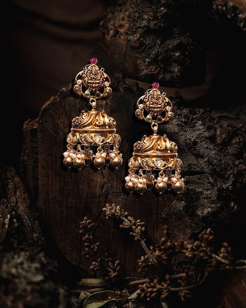 Nakshi lakshmi jhumka pair with gold ball and pearl drops, small ruby top. Photographed at the shop.