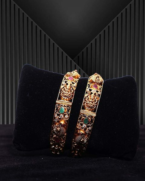 Pair of antique nakshi kadas with Lakshmi and peacock, emerald and ruby stones. Photographed at the shop.