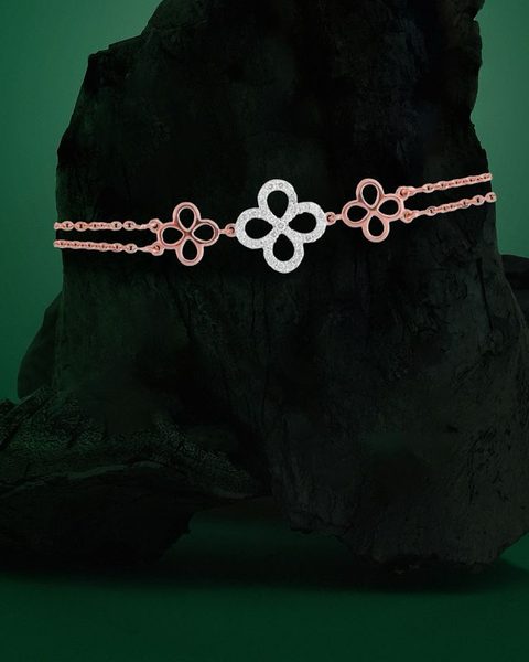 Rose gold diamond bracelet with clover links on charcoal rock. Photographed at the shop.