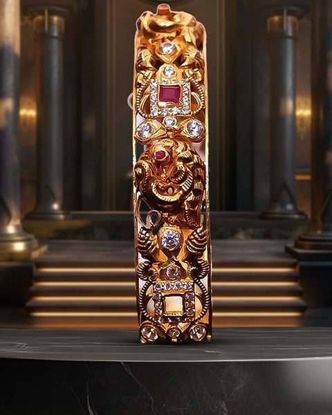 Single nakshi kada with cz and ruby, shown edge on standing upright. Photographed at the shop.