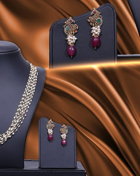 Multi strand pearl necklace with peacock earrings and ruby bead drops. Photographed at the shop.
