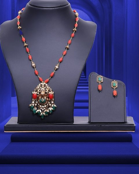Coral bead chain with polki pendant, coral cabochons and emerald drops, matching earrings. Photographed at the shop.