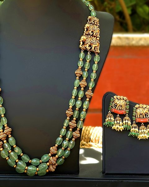 Three strand emerald bead haram with nakshi gold beads, elephant side pieces and elephant earrings. Photographed at the shop.