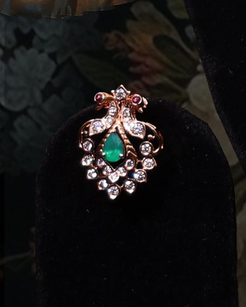 Single stud with twin peacock top, pear emerald centre and CZ border. Photographed at the shop.