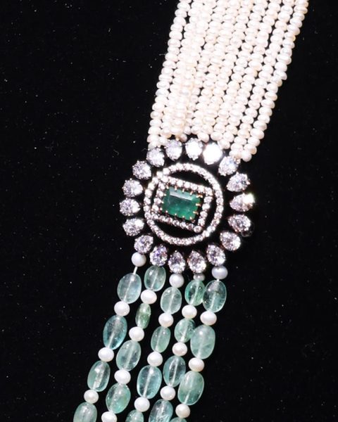 Seed pearl strands joined by a CZ emerald motif to emerald bead strands. Photographed at the shop.