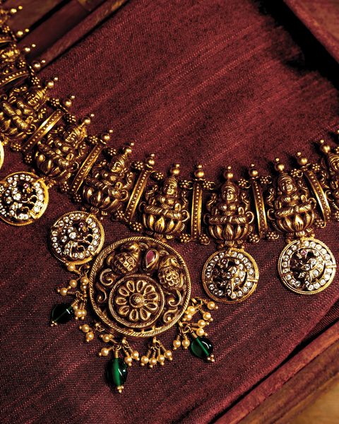Antique nakshi necklace with a row of Lakshmi figures, CZ peacock rounds, floral pendant. Photographed at the shop.