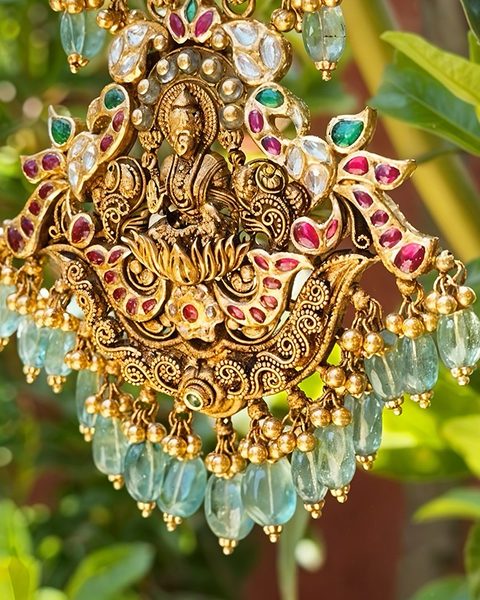 Nakshi lakshmi pendant close up with kempu, polki and pale emerald bead drops. Photographed at the shop.
