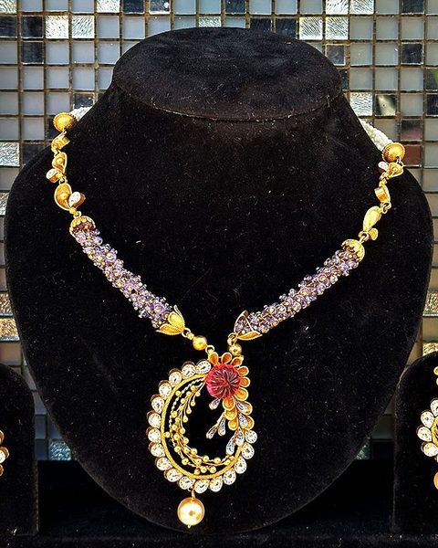 Gold necklace with purple bead sections, paisley cz pendant with red flower, matching earrings. Photographed at the shop.