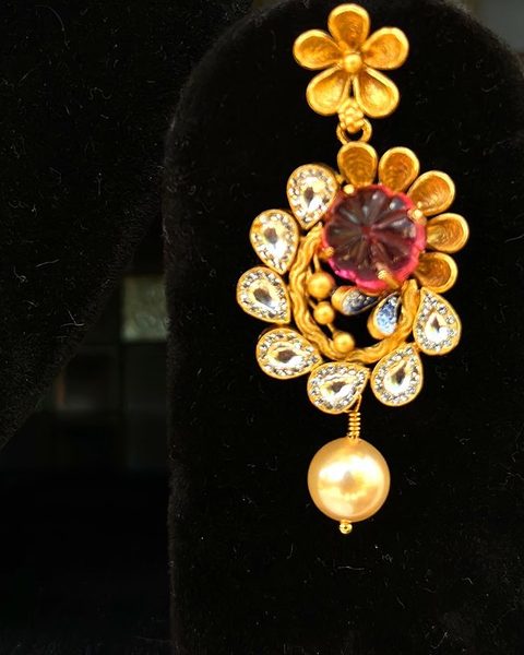 Single flower earring with carved pink stone, cz pear drops and pearl. Photographed at the shop.