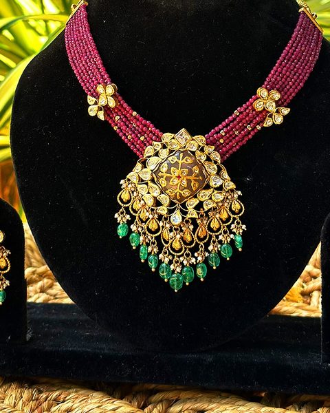 Ruby bead multi strand necklace with polki and enamel pendant, emerald drops, matching earrings. Photographed at the shop.