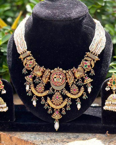 Nakshi kempu choker with pearl strand back, emerald drops and jhumka pair. Photographed at the shop.