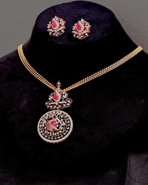 Triple ball chain with round peacock pendant in white stones, matching studs. Photographed at the shop.