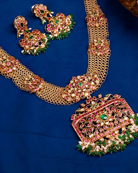 Kempu nakshi long haram with mesh chain, pearl emerald fringe pendant and earrings. Photographed at the shop.