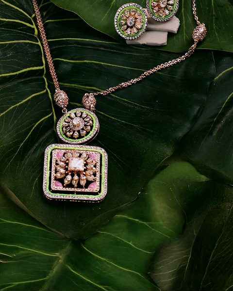 Rose gold cz pendant chain with green enamel border and matching studs. Photographed at the shop.