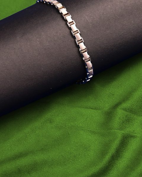 Men's platinum link bracelet with rose gold bars on black cylinder. Photographed at the shop.