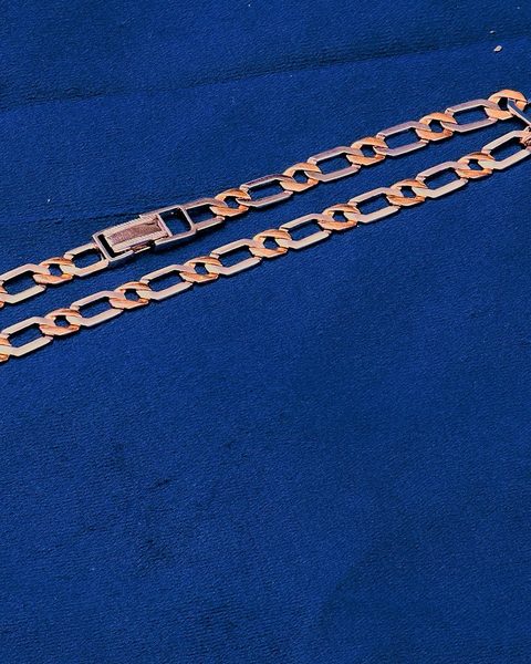 Mens two tone figaro link chain, rose and white metal, on blue velvet. Photographed at the shop.