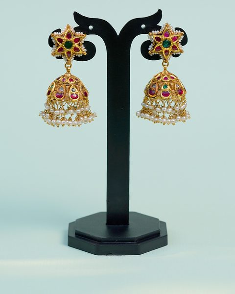 Pair of star top jhumkas with ruby and emerald stones and pearl fringe. Photographed at the shop.