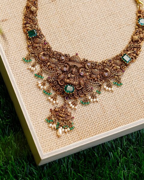 Short nakshi necklace with lakshmi pendant, emerald stones, pearl and green bead drops. Photographed at the shop.