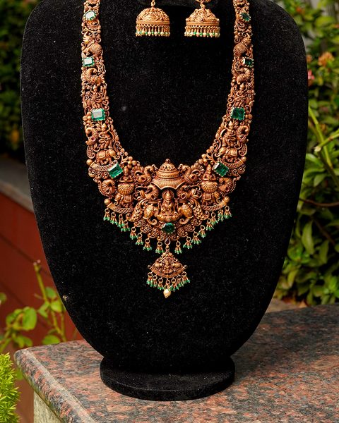 Long nakshi haram with Lakshmi pendant, emerald stones and matching jhumkas. Photographed at the shop.