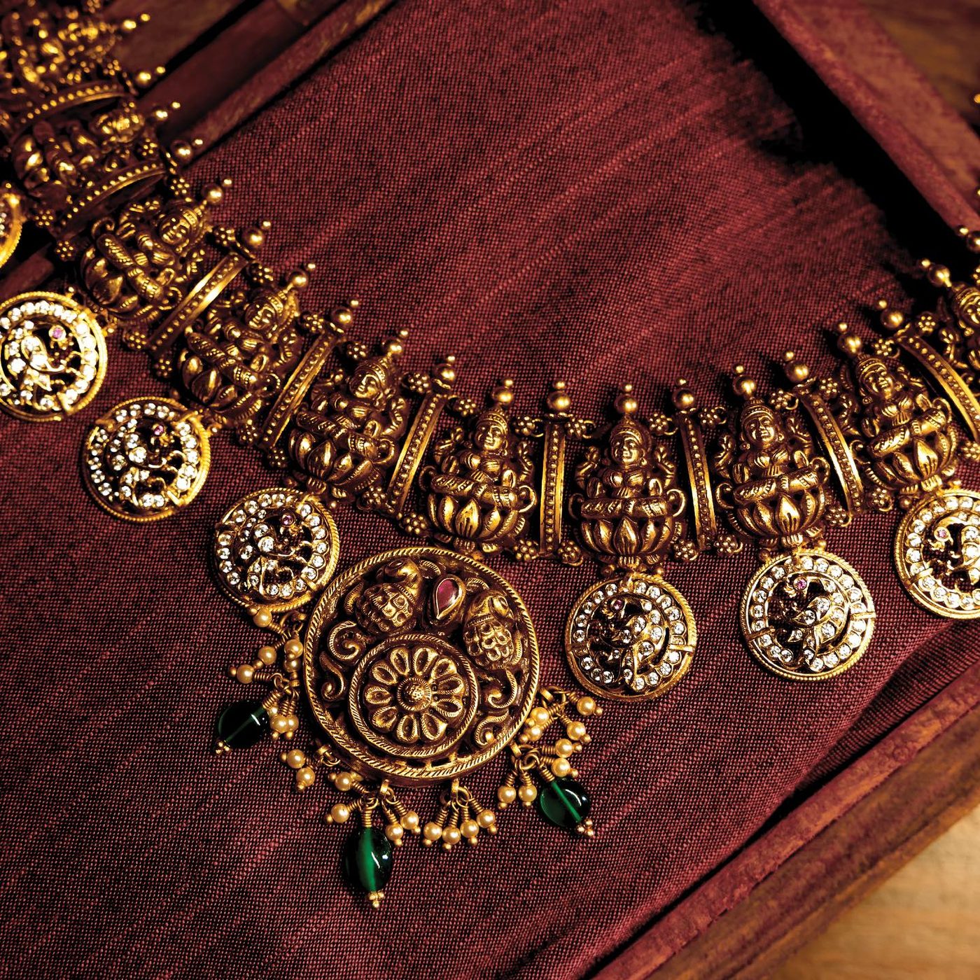 Antique gold coin haram with Lakshmi discs on maroon raw silk.